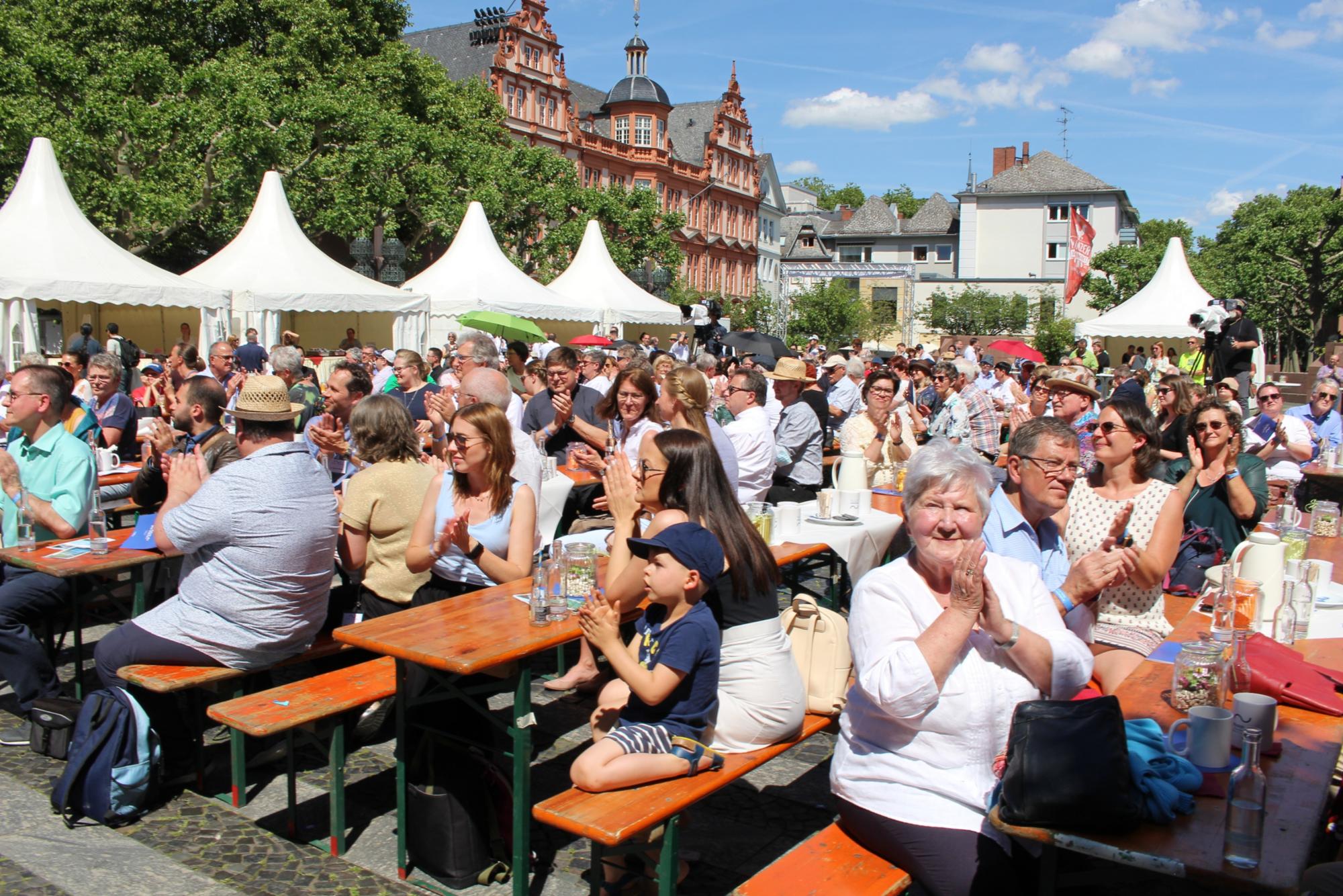 Mainz, 12. Juni 2022: Zu Beginn des Richtfestes saßen die Menschen auf dem Liebfrauenplatz noch in der prallen Sonne. (c) Bistum Mainz / Blum